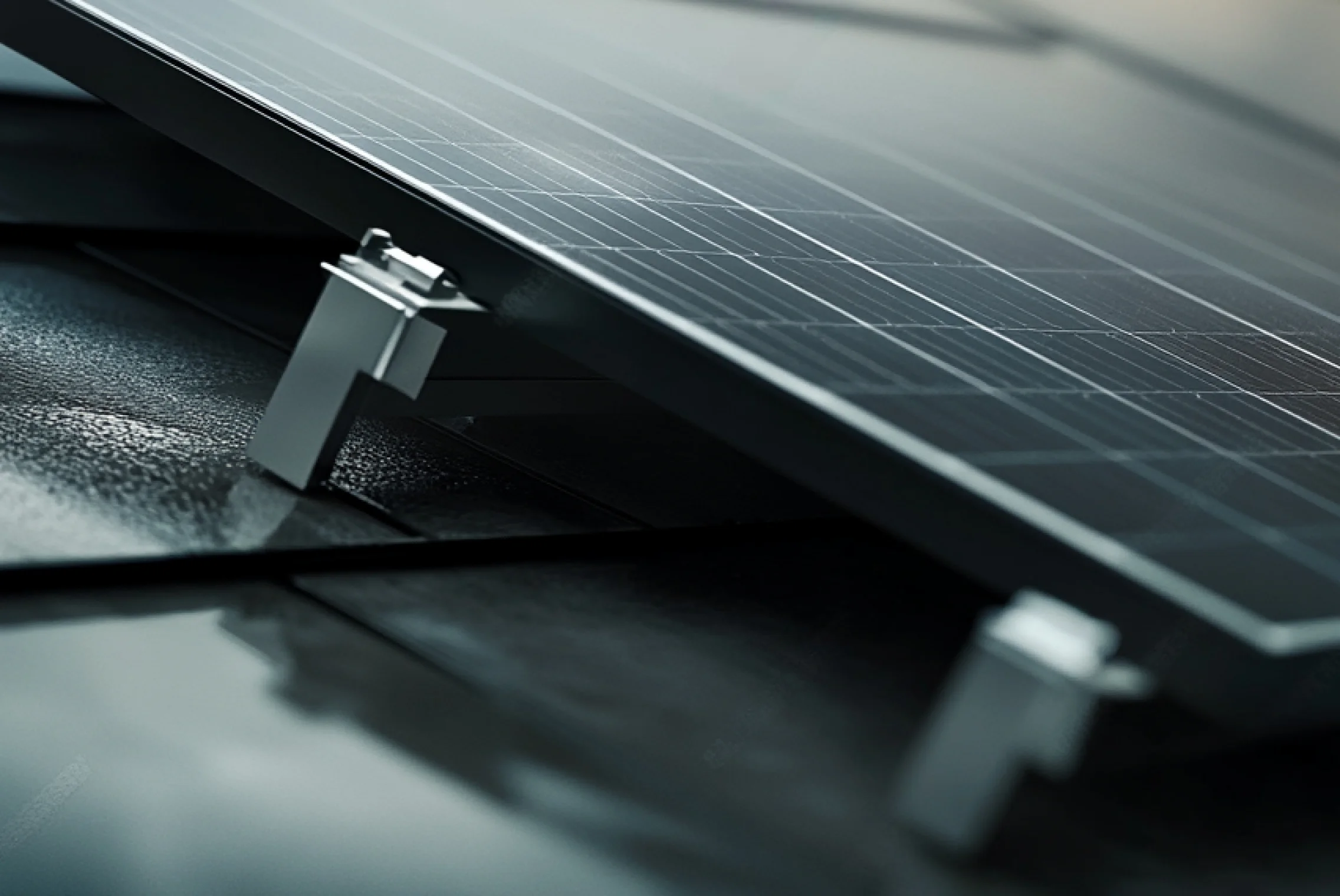 Close-up of a solar panel mounted on a roof with metal brackets
