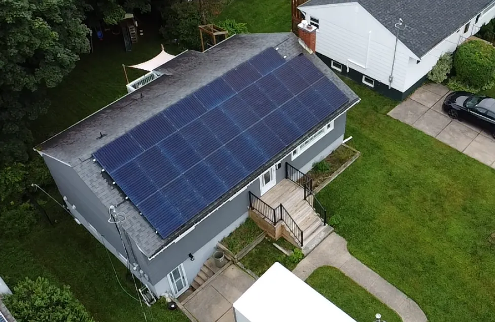 High-angle view of a sleek, full-roof solar array on a Nova Scotia residence, highlighting professional installation and modern aesthetic design.